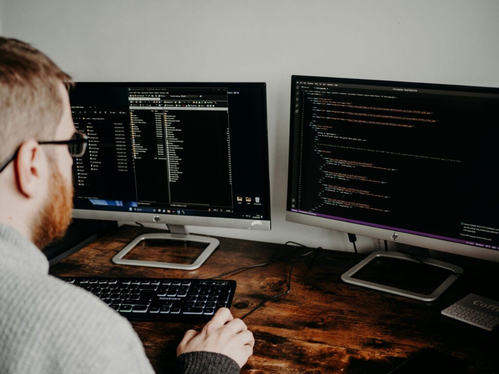 A developer working on website code on a laptop, focusing on optimizing websites for speed.